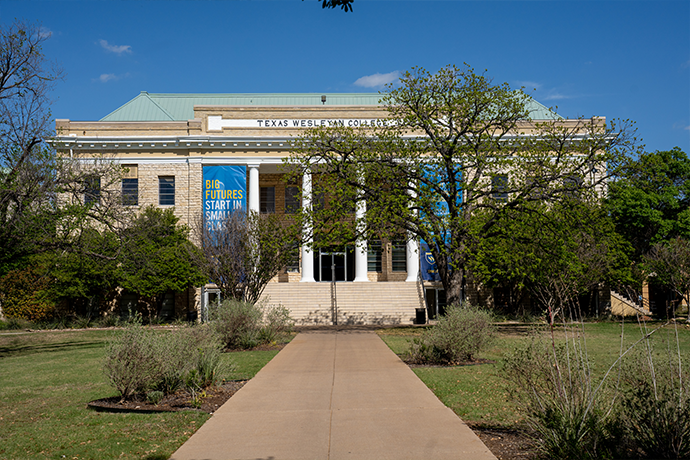 A sidewalk leading to the front of the Oneal-Sells Administration Building on the campus of Texas Ұ Univerasity